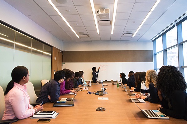 A group of people attending a financial wellness training seminar in a boardroom.