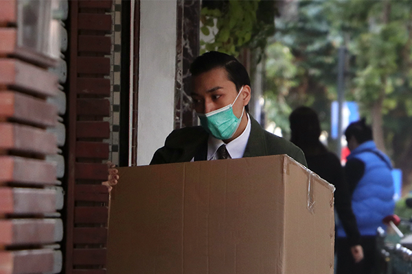 Mature male wearing a face mask while carrying a box of his belongings after being retrenched.